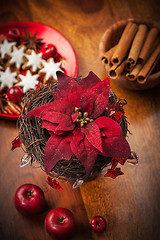 Image showing Christmas flower with decoration on wooden table