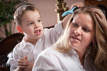 Image showing Cute Son Brushing His Mom's Hair