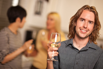 Image showing Smiling Young Man with Glass of Wine Socializing