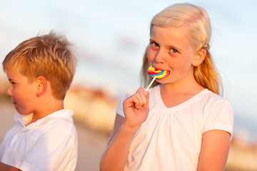 Image showing Cute Little Girl and Brother Enjoying Their Lollipops