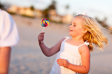 Image showing Adorable Little Girl Enjoying Her Lollipop Outside