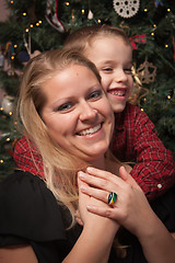 Image showing Adorable Son Hugging His Mom in Front Of Christmas Tree