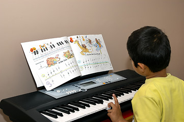 Image showing kid practicing piano
