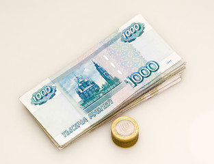 Image showing A bundle of money and a stack of coins 