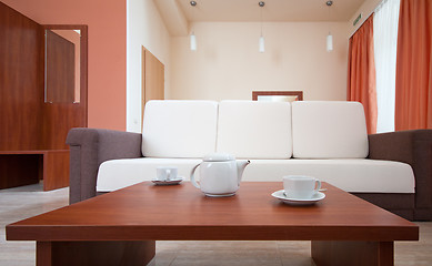 Image showing Teapot and cups on the background of the sofa