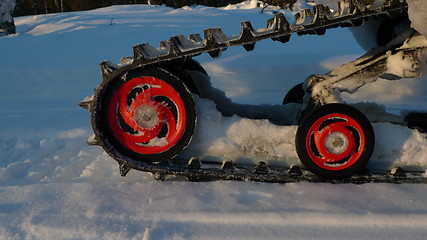 Image showing snowmbile red wheels