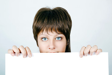 Image showing Face Beautiful Young Woman Hiding Behind A Large White banner