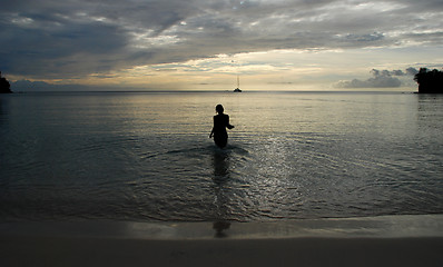Image showing Silhouette of a woman walking into the sea