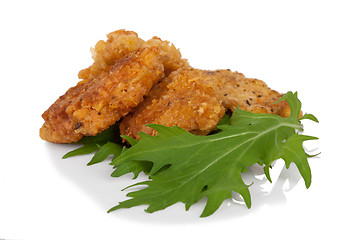 Image showing Breaded chicken sticks with mitsuna salad leaves on white