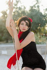 Image showing sensual young woman sitting on a swing