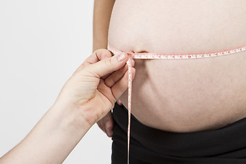 Image showing hand of midwife measuring pregnant belly