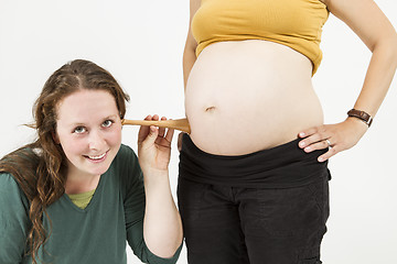 Image showing midwife listening at human belly