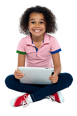 Image showing Cool girl kid sitting on the floor holding tablet pc