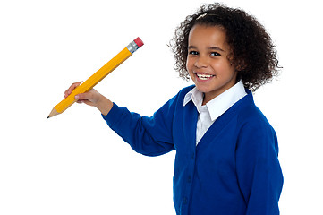 Image showing Pretty school kid facing camera with pencil in hand