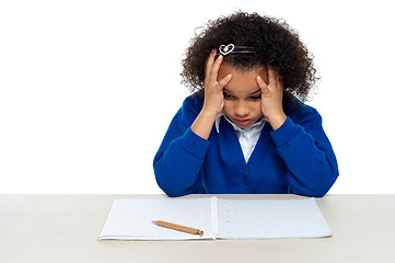 Image showing Stressed out primary girl child holding her head
