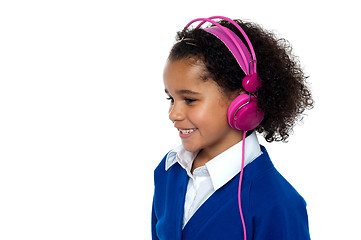 Image showing Charming young kid listening to music