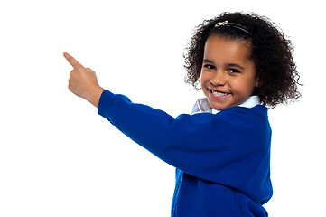 Image showing Adorable African kid pointing at copy space area