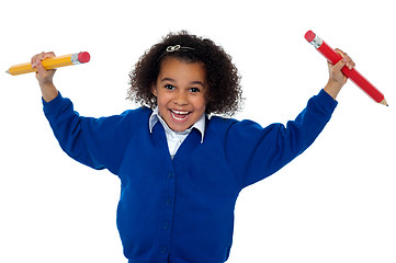 Image showing Fun loving elementary girl dancing with pencils in both her hands