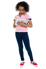 Image showing Young girl super busy in operating new tablet device