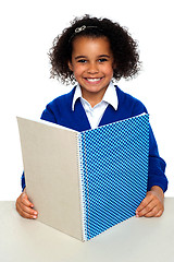 Image showing Smiling school girl learning weekly assignment