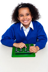 Image showing African elementary school kid using a calculator