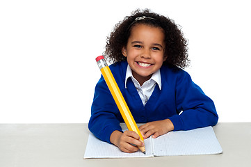 Image showing Pretty girl writing in her notebook