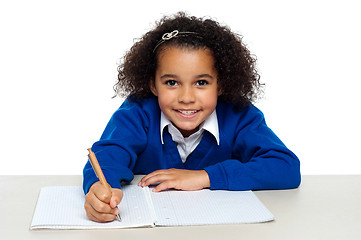 Image showing Young girl writing copying notes from the whiteboard