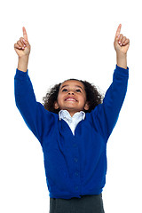 Image showing Amazed young school girl indicating upwards