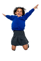 Image showing Jubilant school kid jumping high up in the air