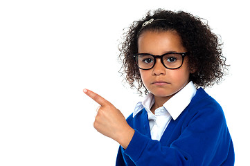 Image showing Studio shot of a melancholic girl pointing sideways