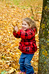 Image showing Little girl playing with leaves