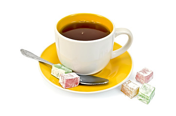 Image showing Tea in yellow cup with lokum