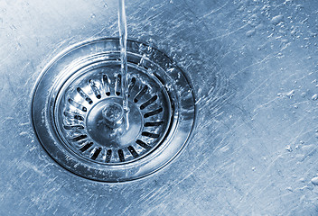 Image showing Water running into kitchen sink drain