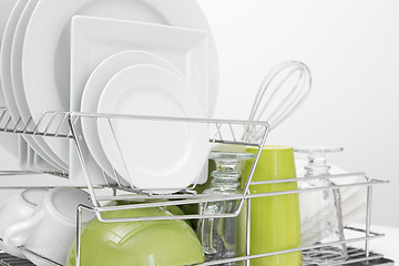 Image showing Green and white dishes drying on dish rack