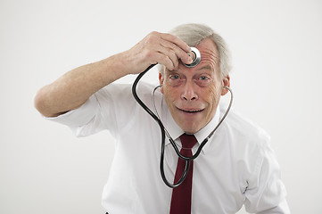 Image showing Senior man holding a stethosope to his forehead