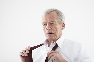 Image showing Elderly man putting on his tie