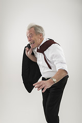 Image showing Senior businessman leaning forwards into wind