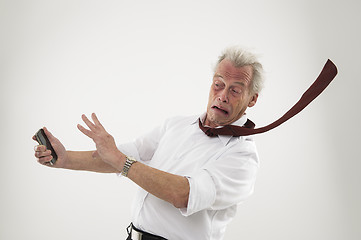 Image showing Senior businessman in the teeth of a hurricane