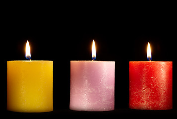 Image showing Three candles on black.