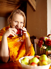 Image showing Young woman is drinking tea and smiling.