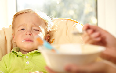 Image showing Kid is very disappointmented about porridge.