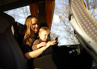 Image showing Mother and kid are playing game on the phone.
