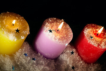 Image showing Three candles with artificial snow.