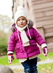 Image showing cute little child in pink jacket and hat outdoor