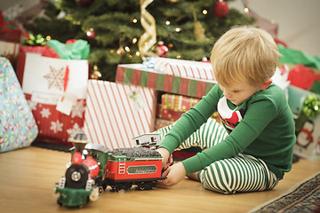 Image showing Young Boy Enjoying Christmas Morning Near The Tree