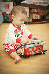 Image showing Infant Baby Enjoying Christmas Morning Near The Tree