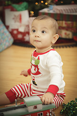 Image showing Infant Baby Enjoying Christmas Morning Near The Tree