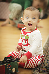 Image showing Infant Baby Enjoying Christmas Morning Near The Tree