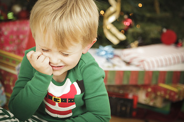 Image showing Young Grumpy Boy Sitting Near Christmas Tree