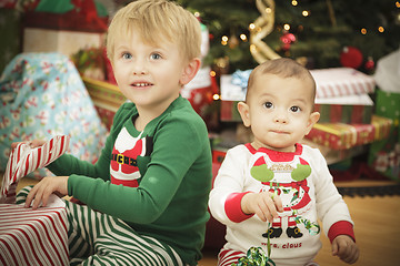 Image showing Baby and Young Boy Enjoying Christmas Morning Near The Tree